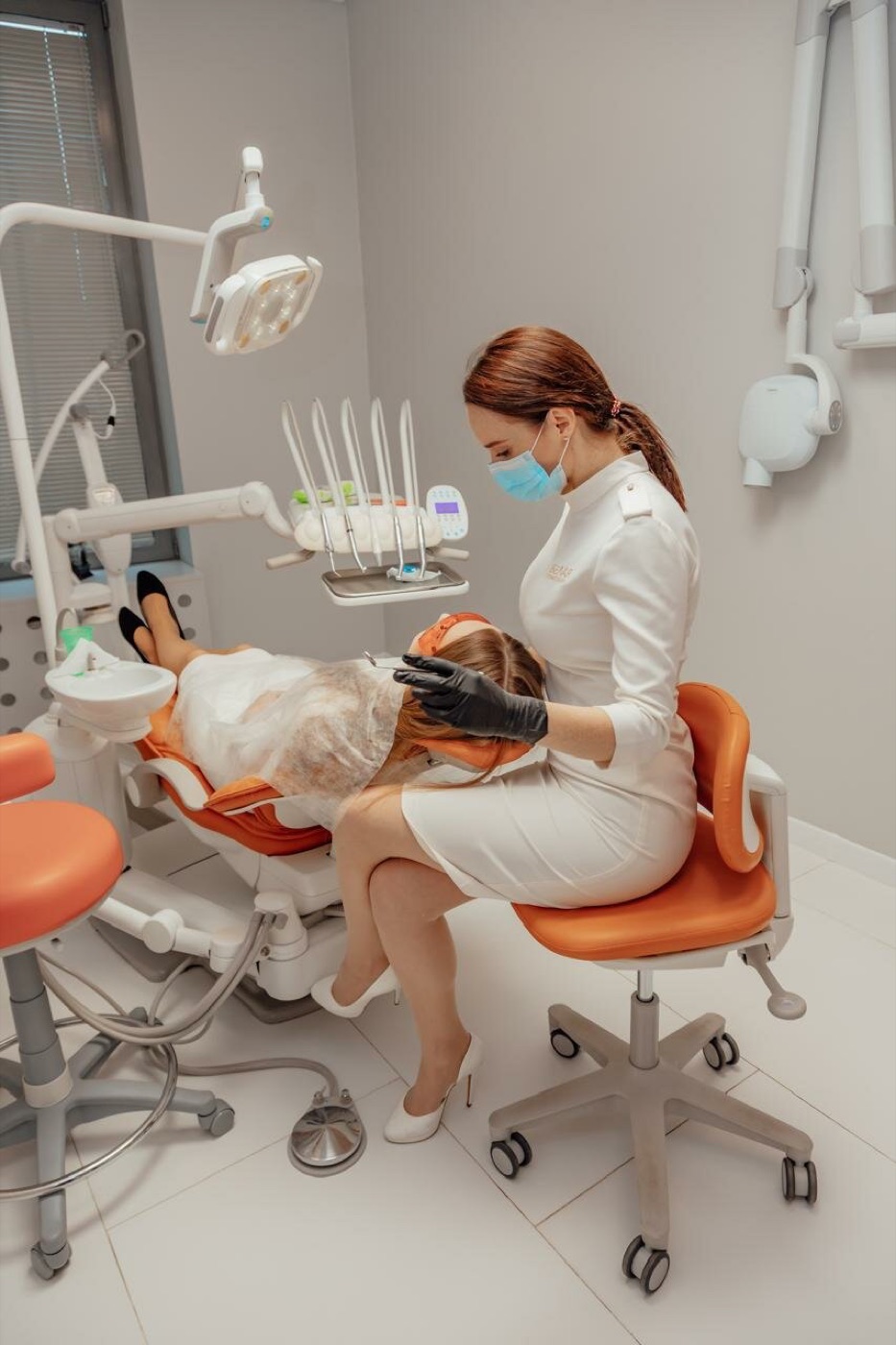 Приём в стоматологической клинике Estetica: пациент в кресле, работа врача